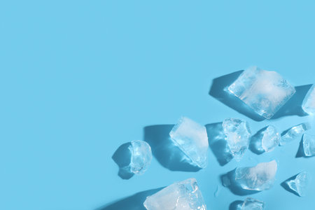 Pieces of frozen ice cubes on blue backgroundの写真素材