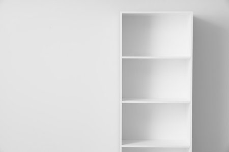 Empty bookshelf near light wallの写真素材