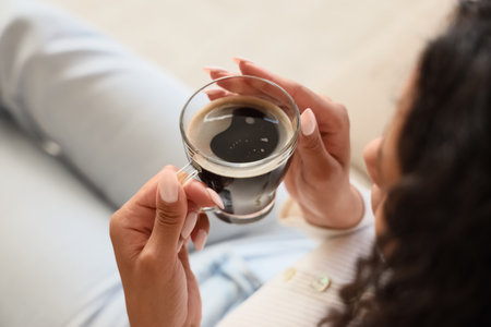 Young woman with cup of coffee sitting at home, closeupの写真素材
