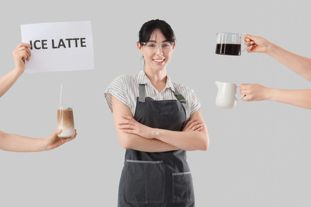 Female barista and hands with ingredients for iced latte on light backgroundの写真素材