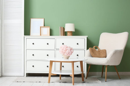 Interior of living room with hydrangea flowers on table and armchair