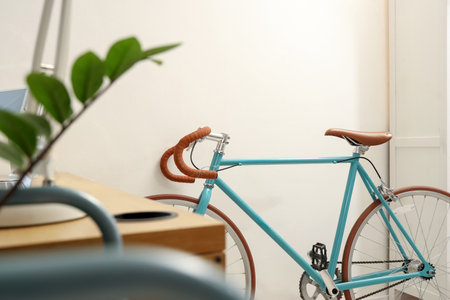 Modern bicycle near light wall in home officeの写真素材