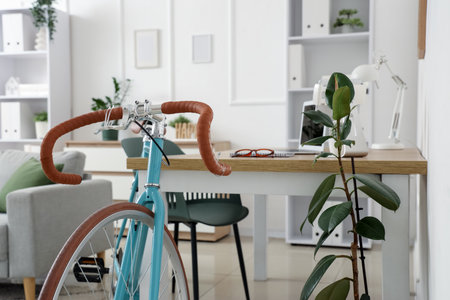 Modern bicycle near workplace in home officeの写真素材