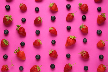 Fresh ripe strawberries and blueberries on pink backgroundの写真素材