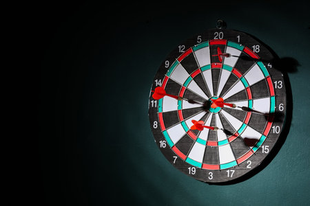 Board with darts hanging on green wallの写真素材