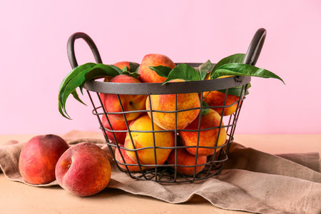 Basket of fresh peaches on pink backgroundの写真素材