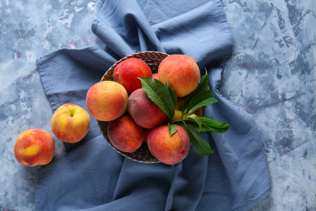 Bowl of fresh peaches on blue background, top viewの写真素材