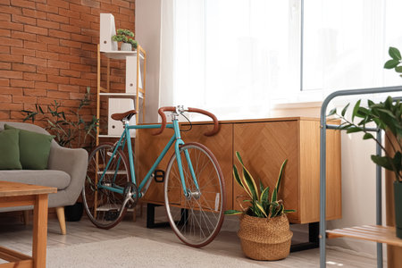 Modern bicycle near chest of drawers in home office interiorの写真素材