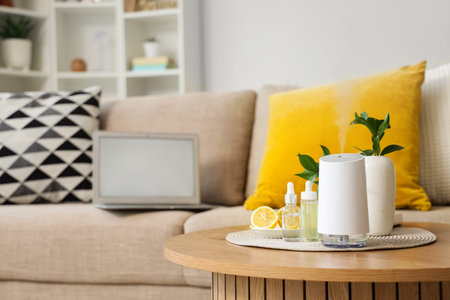 Air humidifier with essential oils and lemon on table in living room, closeup