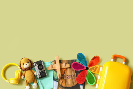 Composition with children's suitcase, photo camera, book and toys on green background, closeupの写真素材