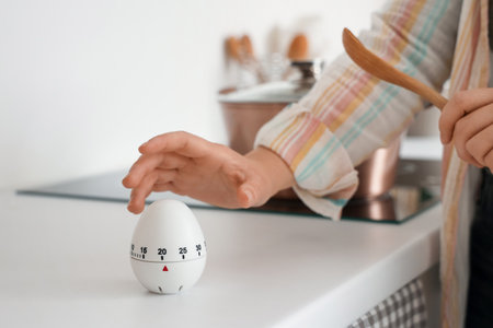 Woman with kitchen timer cooking on counter in room, closeupの写真素材