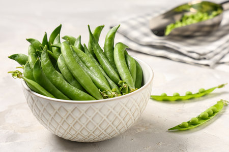 Bowl with green pea pods on gray background, closeupの写真素材