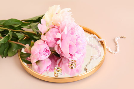 Mirror, jewelery and beautiful peony flowers on pink background, closeupの写真素材