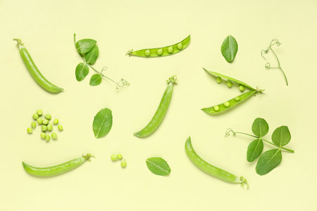Green pea pods and leaves on color background