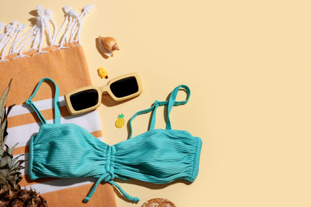 Summer composition with swimsuit and beach accessories on beige background