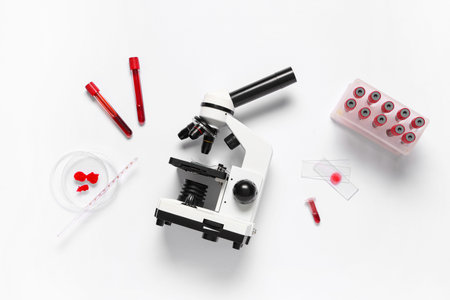 Modern microscope with blood samples and petri dish on white background