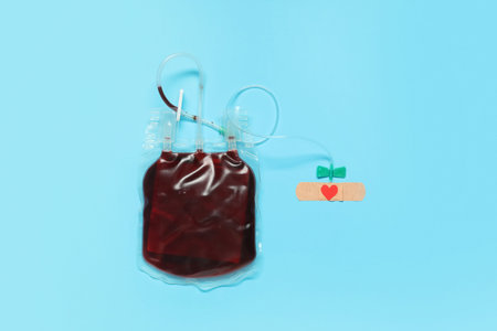 Blood pack for transfusion with medical patch on blue background. Blood donation concept
