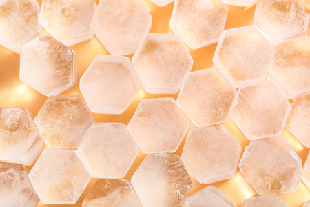 Frozen ice in shape of hexagon on yellow background, closeupの写真素材