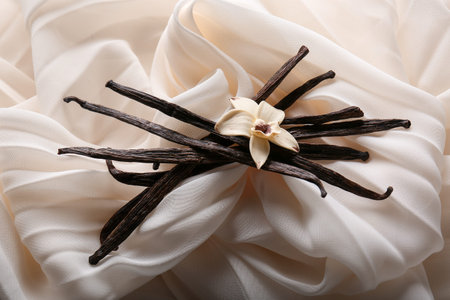 Vanilla sticks and flowers on white cloth