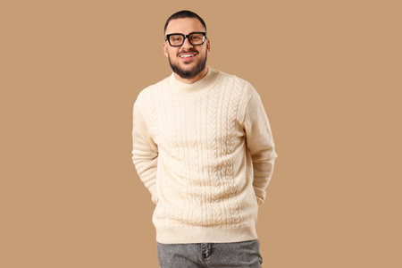 Handsome young man in eyeglasses on beige backgroundの写真素材