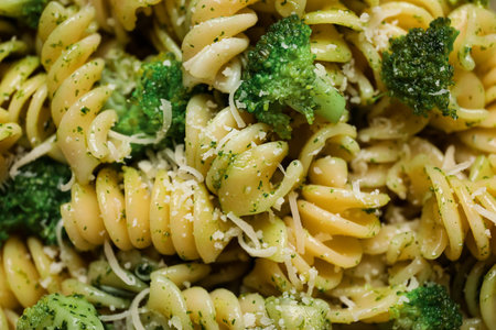 Texture of delicious fusilli pasta with broccoli and cheese as background, closeup