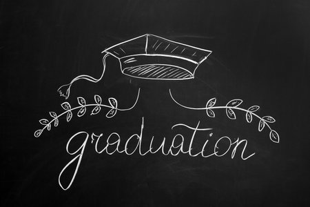 Word GRADUATION with drawn mortar board and wreath on blackboardの写真素材