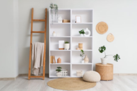 Blurred view of light room with shelf unit, ladder and plantsの写真素材