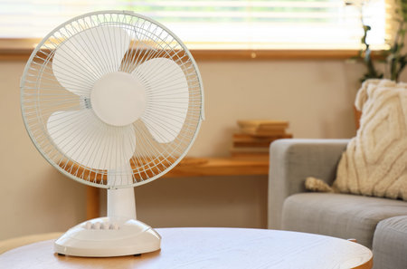 Electric fan on table in living roomの写真素材