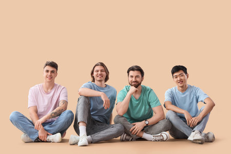 Sitting young men on beige backgroundの写真素材