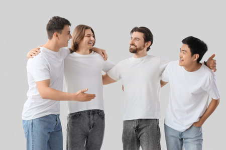 Group of young men in white t-shirts on light background