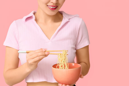 Young woman with tasty ramen on pink background, closeupの写真素材