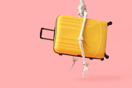 Human skeleton with suitcase flying on pink background. Travel conceptの写真素材