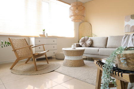 Interior of living room with gray sofa, armchair and rattan table