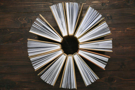 Circle made of many different books on wooden backgroundの写真素材