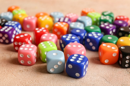 Many colorful dices on beige background