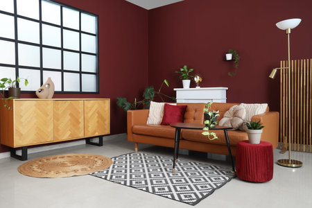 Interior of modern living room with cozy brown sofa, coffee table, ottoman