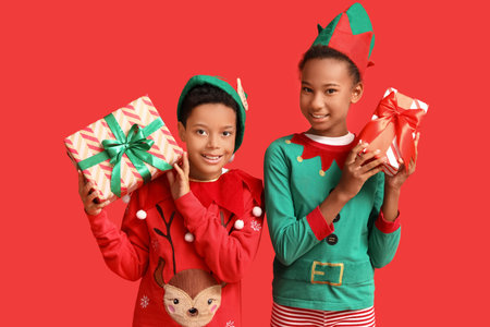 African-American children dressed as elves with Christmas presents on red background