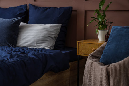 Big bed with navy blue linen in room