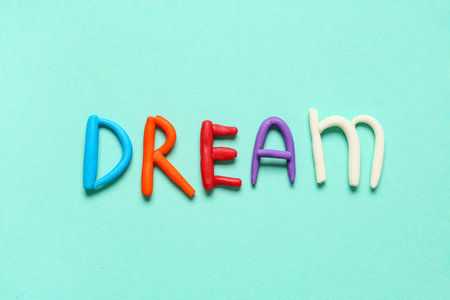 Word DREAM made of play dough on light blue backgroundの写真素材