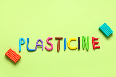 Word PLASTICINE made of play dough on green backgroundの写真素材