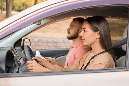 Young woman with instructor passing driving license test in car