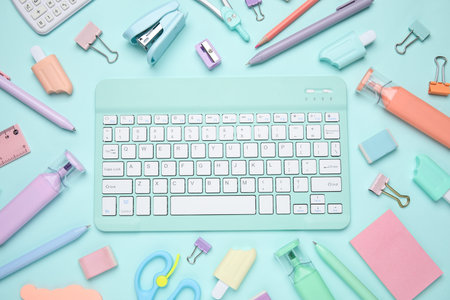 Set of school supplies with computer keyboard on blue background, closeup