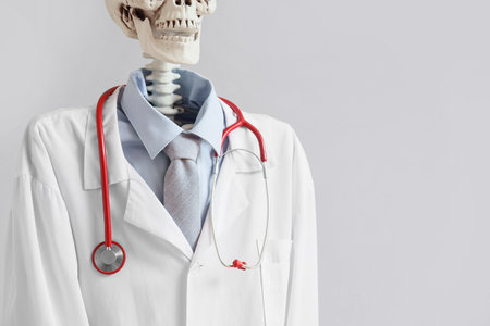 Human skeleton model in doctor's uniform with stethoscope on light background, closeupの写真素材