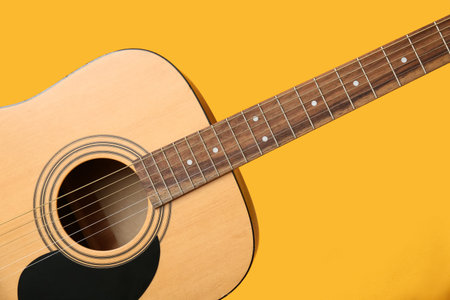Modern guitar on yellow background, closeup