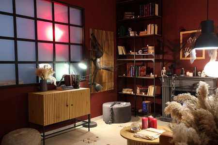 Interior of living room decorated for Halloween with bookshelf, fireplace and glowing lampの写真素材
