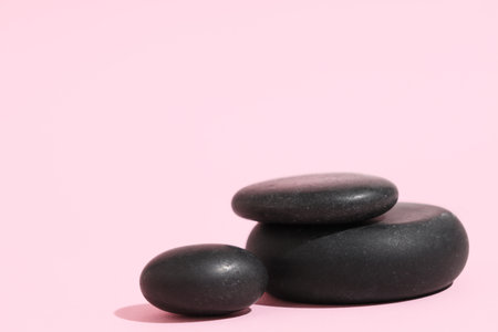 Black pebbles on pink background. Zen conceptの写真素材