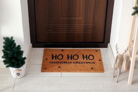 Doormat with Christmas greeting and fir tree in hallwayの写真素材