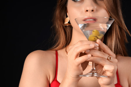 Beautiful woman with martini on black background, closeupの写真素材
