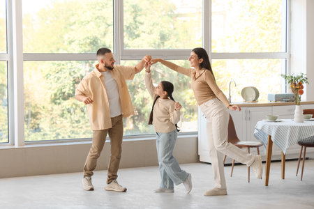 Happy parents with their little daughter dancing in kitchenの写真素材