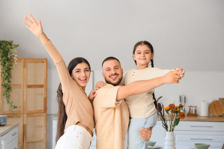 Happy parents with their little daughter dancing in kitchenの写真素材
